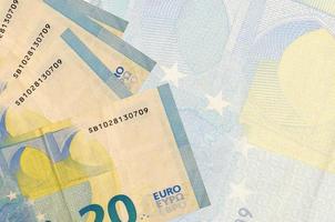 20 billets en euros sont empilés sur fond de gros billets semi-transparents. arrière-plan abstrait des affaires photo