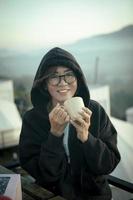 femme d'âge moyen à pleines dents souriant avec bonheur face tenant une tasse de café à la main photo