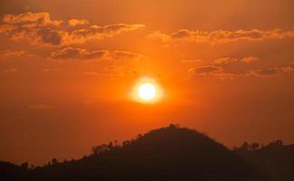 le soleil sur le ciel orange le matin et la vue sur la montagne photo