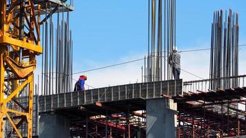 ingénieur et ouvriers sur le chantier de construction de bâtiments élevés et la texture de l'acier et du ciment et le ciel bleu. photo