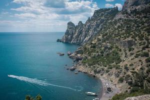 bateaux à moteur sur la photo de paysage de plage rocheuse