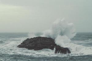 vagues se brisant sur une grande falaise paysage photo