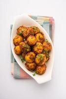 pommes de terre bombay rôties maison. petites pommes de terre sautées à la poêle ou aloo avec graines de jeera et coriandre dans un bol photo