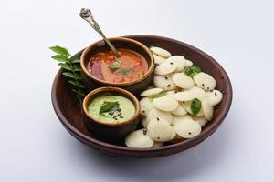 Le mini idli est la version plus petite de l'idli de riz régulier cuit à la vapeur de forme ronde douce et spongieuse, également connu sous le nom de bouton et de cocktail. photo