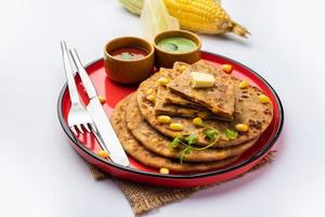 paratha ou parotha farcis au maïs sucré servis dans une assiette, recette de pain plat indien faite de remplissage makai photo