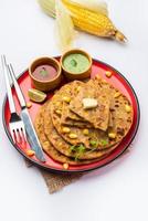 paratha ou parotha farcis au maïs sucré servis dans une assiette, recette de pain plat indien faite de remplissage makai photo