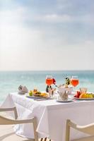 petit-déjeuner de luxe sur une table blanche, avec un beau fond de vue sur la mer tropicale, des vacances d'été le matin et un concept de vacances romantiques, des voyages de luxe et un style de vie photo