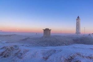 panorama sur les dunes et le phare de la station balnéaire danoise de blavand au lever du soleil photo