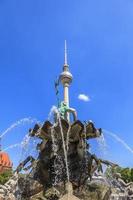 vue de la fontaine de neptune à berlin avec tour de télévision en arrière-plan photo