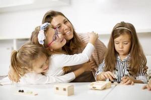 groupe de petits enfants mignons jouant avec des jouets éducatifs préscolaires avec un enseignant de maternelle photo