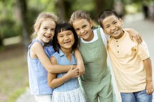 groupe d'enfants asiatiques et caucasiens s'amusant dans le parc photo