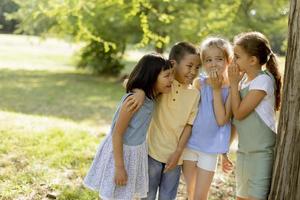 groupe d'enfants asiatiques et caucasiens s'amusant dans le parc photo