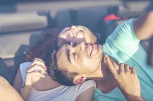 amis s'amusant lors d'un voyage en voiture autour du monde. couple amoureux avec les bras levés sur une voiture décapotable. photo