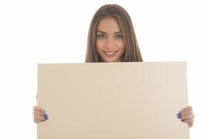 jeune fille souriante tenant un panneau vierge. portrait en studio de jeune femme avec carte de signe. isolée. photo