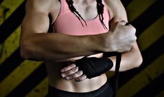 gros plan d'une femme faisant des bandages de boxe dans une cage de combat photo