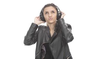 belle fille moderne chantant sa chanson préférée, écoutant de la musique dans des écouteurs sans fil, souriant et dansant photo