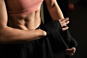 gros plan d'une femme faisant des bandages de boxe dans une cage de combat photo