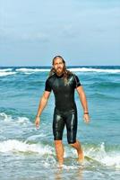 homme sortant de l'océan après avoir surfé sur l'eau photo