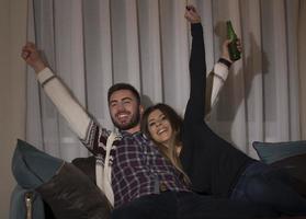 couple s'amusant à regarder un match de foot à la télé photo