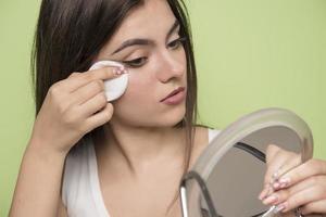 portrait de beauté en gros plan d'une jeune femme séduisante nettoyant son visage avec un coton photo