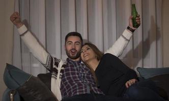 couple s'amusant à regarder un match de foot à la télé photo