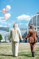 moments d'amour de couple de lesbiennes lgbt. couple de lesbiennes tenant des ballons dans le parc. notion de bonheur photo