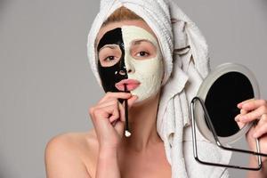 beau modèle féminin avec masque cosmétique facial noir et blanc photo