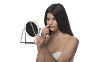 la femme touche la peau du visage regarde le miroir se sentant inquiète des premières rides et des changements liés à l'âge problèmes de derma. concept de soins de la peau de chirurgie plastique faciale cosmétique photo
