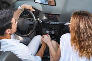 amis s'amusant lors d'un voyage en voiture autour du monde. couple amoureux avec les bras levés sur une voiture décapotable. photo