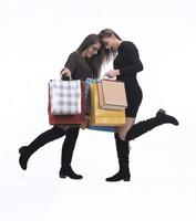 deux amies heureuses avec sac à provisions sur fond de studio isolé. photo