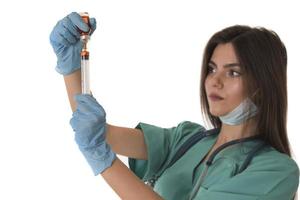 femme infirmière avec des vêtements de travail protecteurs tenant un vaccin et une seringue photo