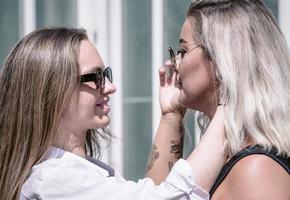 un couple de femme gay souriant et s'embrassant. même sexe jeune couple de femmes mariées dans leur routine quotidienne montrant une certaine affection lgbt photo