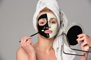 beau modèle féminin avec masque cosmétique facial noir et blanc photo