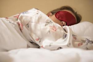 une jeune femme dormant avec un masque couvrant les yeux. photo