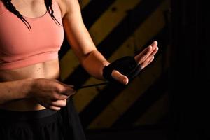 gros plan d'une femme faisant des bandages de boxe dans une cage de combat photo