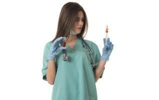 femme infirmière avec des vêtements de travail protecteurs tenant un vaccin et une seringue photo