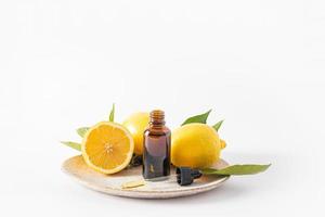 flacon cosmétique en verre foncé avec de l'huile de citron biologique, un sérum à base d'huile essentielle pour les soins de la peau du visage. cosmétique végétale.