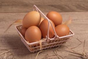 oeufs frais dans un panier sur un fond en bois. espace de copie. photo