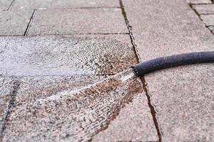 fuite d'eau du tuyau dans une rue de la ville photo