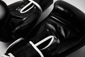 paire de gants de boxe noirs sur fond blanc, gros plan photo