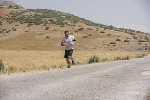 coureur d'homme sportif courant sur le plateau de montagne en été photo