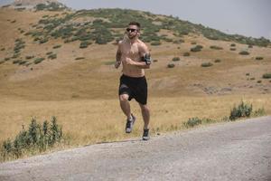 coureur d'homme sportif courant sur le plateau de montagne en été photo