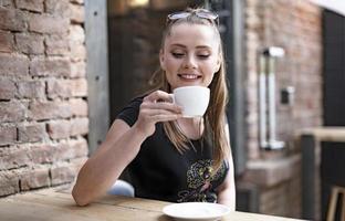belle fille tenant une tasse de café au café-bar. photo