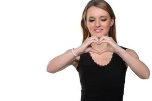 portrait d'une jeune femme faisant un geste de coeur avec ses mains photo