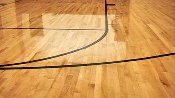 intérieur d'un terrain de sport intérieur de basket-ball moderne vide, revêtement de sol en bois semi-brillant, lumières artificielles réfléchies photo