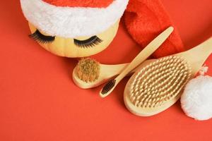 brosse à dents en bambou, brosses de massage en bois, citrouille avec faux cils et serviette sur fond gris photo