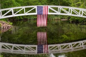 passerelle à somesville, île déserte du mont dans le maine avec le drapeau américain se reflétant dans l'étang.