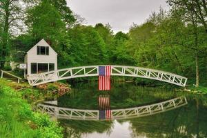 passerelle à somesville, île déserte du mont dans le maine avec le drapeau américain se reflétant dans l'étang. photo