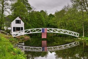 passerelle à somesville, île déserte du mont dans le maine avec le drapeau américain se reflétant dans l'étang. photo