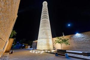 minaret jummi dans la vieille ville de khiva, ouzbékistan la nuit. mince minaret appartenant à la mosquée jummi photo